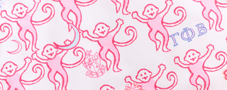 Pattern of pink monkeys on a white background, some holding hands. Greek letters and small illustrations, including a crest and crescent moon, are scattered among the monkeys.