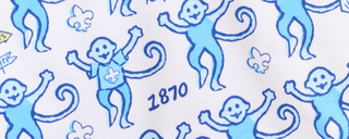 Pattern of blue cartoon monkeys with raised arms, some wearing shirts with a fleur-de-lis, and the number 1870 on a white background.