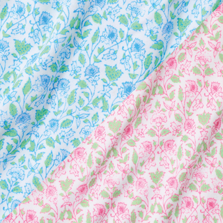 Close-up of fabric with a floral pattern in blue, green, and pink colors. The fabric appears soft and is diagonally divided between blue and pink sections featuring delicate flower designs.