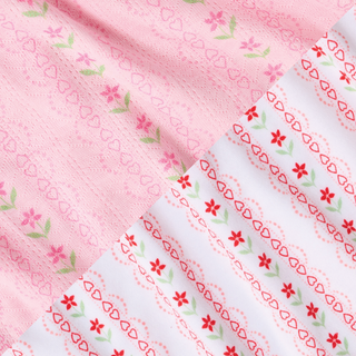 Two fabric patterns: one pink with small flowers and hearts, another white with red flowers and scalloped lines. Both have delicate, repeating floral and heart motifs in soft colors.
