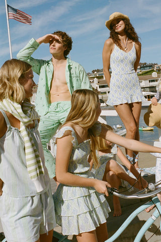 Women, men, and kids in Roller Rabbit clothing and swimwear on a dock