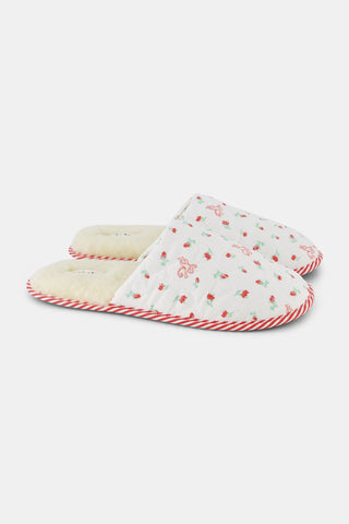 The Mini Monkey Blossom Quilted Slipper by Roller Rabbit features a white quilted design with a floral pattern, red trim, and a soft beige fuzzy lining, displayed on a plain white background.