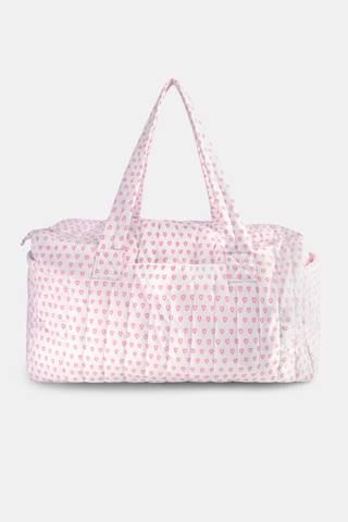 The Roller Rabbit Hearts Quilted Weekender is a rectangular pink and white travel bag with two handles, showcasing a pink heart pattern on quilted nylon, set against a plain light gray background.