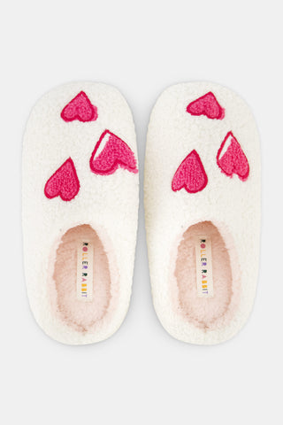 Kids Hearts Fuzzy Slippers: a pair of cream-colored fuzzy kids slippers decorated with red heart appliques.