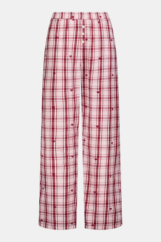 A woman wearing a SAPPHIRE Plaid Hearts Perlita Night Shirt in a pink and maroon plaid pattern with small hearts.