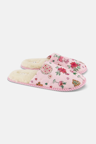 LUHE Seasons Soiree Quilted Slippers in pink, featuring a cream faux fur lining and a pattern of holiday treats, poinsettias, and champagne glasses.