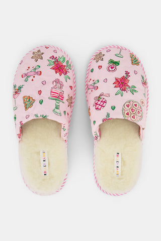 LUHE Seasons Soiree Quilted Slippers in pink, featuring a cream faux fur lining and a pattern of holiday treats, poinsettias, and champagne glasses.