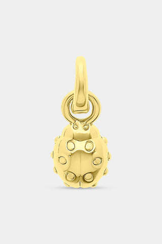 The Roller Rabbit Ladybug Charm is a small golden accessory featuring raised dots and a convenient loop at the top for attaching to jewelry, making it perfect for adding to a charm bracelet. It is showcased against a light gray background.