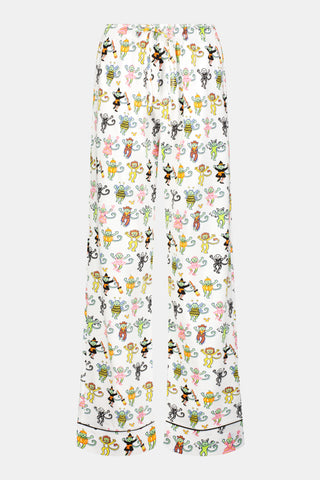 A person stands barefoot against a plain white background, wearing white Roller Rabbit Mens Boo Crew Simon Pants featuring colorful cartoon character prints. The shirt is slightly lifted, revealing the soft Pima cotton waistband.