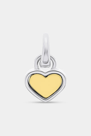 The Roller Rabbit Heart Charm is a heart-shaped pendant with a yellow gold center and a silver border, designed with a top loop for easy attachment to your favorite bracelet or necklace. It is displayed against a plain light gray background.