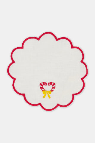 Seasons Soiree Scallop Cocktail Napkin Set Of 4: four round 100 linen napkins with scalloped red edges, each featuring a different embroidered Christmas icon: a tree, holly, a candy cane, and bells.