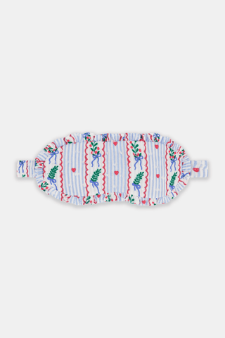 SANSKRITI Mistletoe Stripe Eye Mask in blue and white stripes, crafted from 100 cotton with embroidered mistletoe, red hearts, and blue bows finished with a ruffled edge.