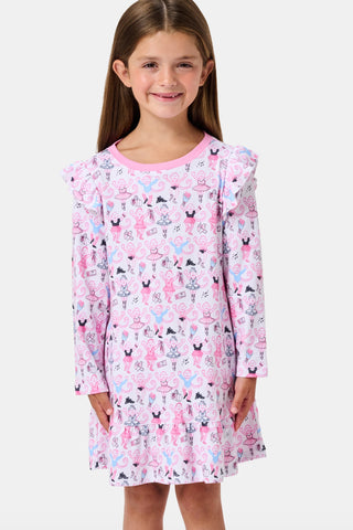The Roller Rabbit Kids Monkey Pirouette Isa Dress features long sleeves, a pink collar, and ruffle shoulders. Crafted from soft Pima Cotton for all-day comfort, this dress showcases a playful pattern of cartoon monkeys dancing pirouettes on a white background.
