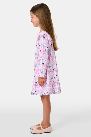 The Roller Rabbit Kids Monkey Pirouette Isa Dress features long sleeves, a pink collar, and ruffle shoulders. Crafted from soft Pima Cotton for all-day comfort, this dress showcases a playful pattern of cartoon monkeys dancing pirouettes on a white background.