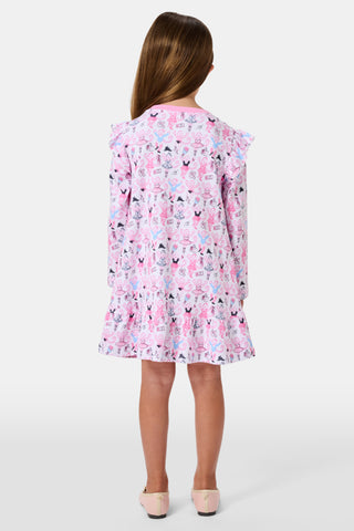 The Roller Rabbit Kids Monkey Pirouette Isa Dress features long sleeves, a pink collar, and ruffle shoulders. Crafted from soft Pima Cotton for all-day comfort, this dress showcases a playful pattern of cartoon monkeys dancing pirouettes on a white background.