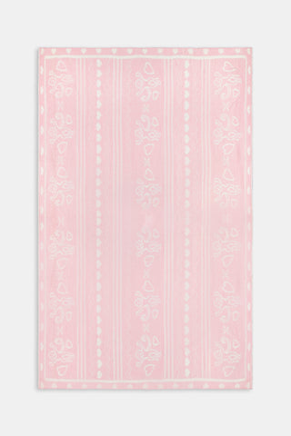 Folded pink and white Fairisle Hearts Dreams blanket featuring heart, vine, and Cupid patterns by BETTEX.