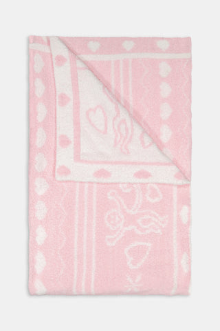 Folded pink and white Fairisle Hearts Dreams blanket featuring heart, vine, and Cupid patterns by BETTEX.
