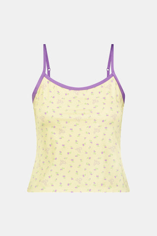 A yellow Mini Monkey Blossom Clarkson Cami by Roller Rabbit, featuring spaghetti straps, a small floral print, and purple trim along the neckline and straps, displayed on a plain white background. This camisole pairs perfectly with the Monroe Lounge Pant for a coordinated look.