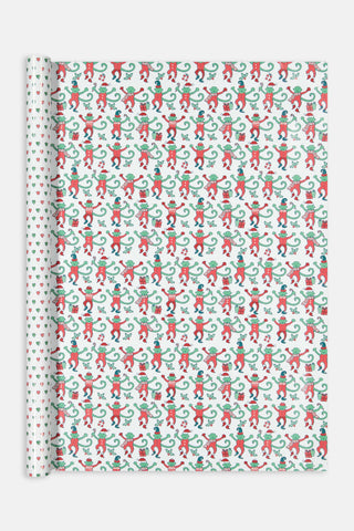 Monkey Mas/Holiday Hearts Wrapping Paper featuring a pattern of green monkeys in Santa hats and outfits on one side, and a pattern of small Holiday Hearts on the other.