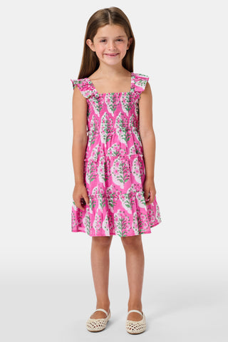 The Kids Ava Floral Ceri Dress by Roller Rabbit is a sleeveless baby dress featuring a smocked bodice and ruffled straps, adorned with green and white leaf patterns on a vibrant pink background, and comes with matching bloomers.