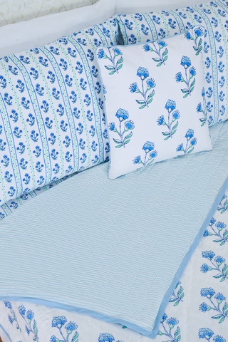 The Rosa Wavy Stripe Sheet Set by Roller Rabbit features a white sheet with blue floral print and green wavy stripes, ideal for twin XL beds or anyone seeking stylish cotton bedding.