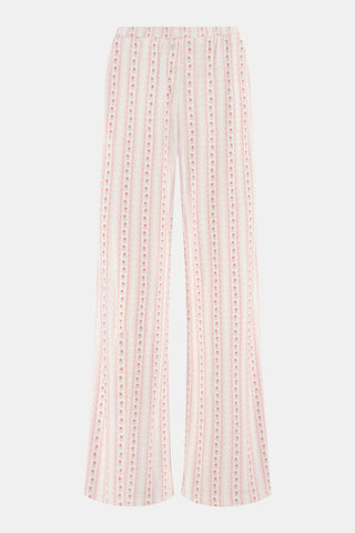 The Daisy Heart Stripe Boden Pant by Roller Rabbit features a wide-leg silhouette with a white base, adorned with vertical pink floral and dotted stripes. Designed for comfort, these pajama pants have an elastic waistband and are crafted from soft Pima cotton for a luxurious feel.