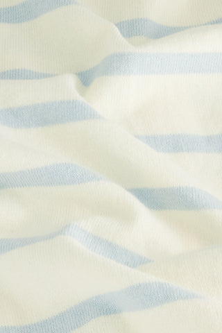 A close-up of the Stripe Florence Sweater, featuring soft cream and blue knit fabric with light blue and white horizontal stripes, displaying gentle folds and a smooth texture.