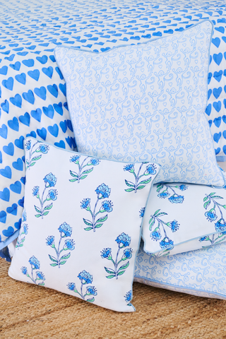 The Roller Rabbit Rosa Floral Decorative Pillow features a white cotton base with blue and light blue floral patterns, green leaves outlined in black, and a thin light blue border—perfect for adding a botanical accent to your decor.