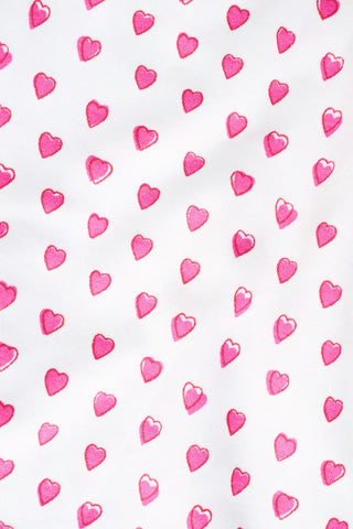 The Roller Rabbit Infant Hearts Short Sleeve Zipper Onesie is a white baby romper with short sleeves, adorned with a charming repeating hearts print and designed with a convenient diagonal zipper running from the neckline to one leg.