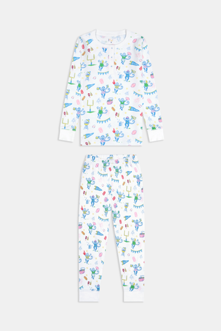 The Kids Game Day Pajamas by Roller Rabbit are a children’s long-sleeve pajama set crafted from soft Pima cotton, featuring a vibrant party-themed print with colorful dinosaurs, bunting, gifts, and party hats on a white background.