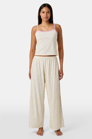 A yellow Mini Monkey Blossom Clarkson Cami by Roller Rabbit, featuring spaghetti straps, a small floral print, and purple trim along the neckline and straps, displayed on a plain white background. This camisole pairs perfectly with the Monroe Lounge Pant for a coordinated look.