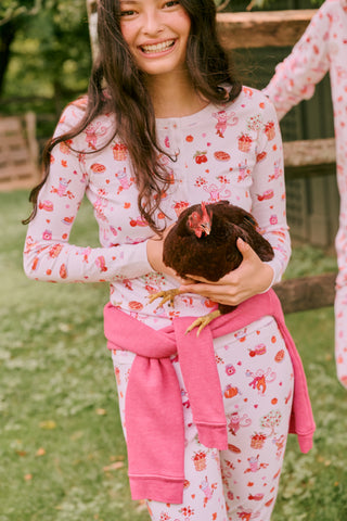 A girl wearing Roller Rabbit Kids Sweater Weather Pajamas stands barefoot, smiling, against a plain white background.