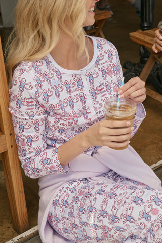 The Roller Rabbit Pi Beta Phi Monkey Pajamas are a long-sleeve set featuring a Henley top and pants, both adorned with a repeating red and blue monkey print on a white background. Made from soft Pima cotton, these pajamas are lightweight and comfortable.