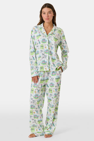 Introducing the Game, Set, Monkey Long Sleeve Polo Pajamas by Roller Rabbit—a cozy white pajama set expertly crafted from soft Pima Cotton. The set features a playful Game Set Monkey print with vibrant green, blue, and yellow animal and nature illustrations. Designed with long sleeves, a button-up polo top, and comfortable drawstring waist pants, this delightful set is showcased against a plain light background.