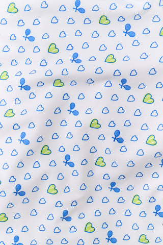 The Roller Rabbit Tennis Hearts Becky Active Dress is a sleeveless white active dress with a V-neckline and a flared skirt, adorned with an all-over pattern of small blue and green heart shapes. The dress is shown against a plain light gray background.
