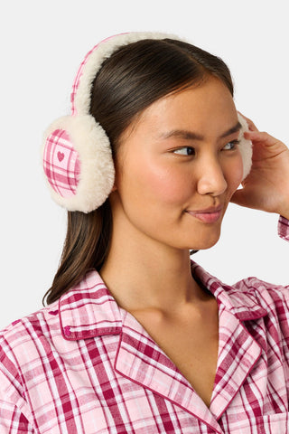 A person wearing LUHE Plaid Hearts Earmuffs in a cozy pink and white plaid pattern with heart details.