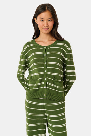 A woman stands facing forward, wearing the Roller Rabbit Autumn Stripe Laine Cardigan in olive green stripes with buttons and matching pants. She has long dark hair and a slight smile.