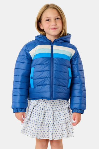 A child wears a blue SOPHISTICA Kids Monkey Reversible Puffer Jacket featuring heart-shaped quilting, a white and light blue chest stripe, and a hood.