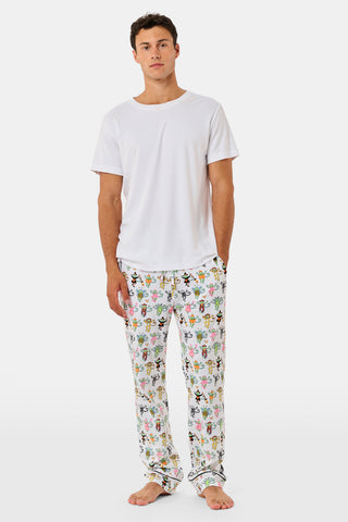A smiling child in Roller Rabbit’s Kids Boo Crew Pajamas, crafted from soft Pima cotton, sits with arms raised on outdoor steps among women in coordinating patterned pajamas, all sharing a cheerful and relaxed moment together.