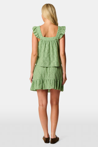 A woman wearing the Roller Rabbit Elsa Eyelet Nicole Top in sage green cotton, featuring an eyelet pattern and ruffled shoulder straps, shown from the shoulders to the waist against a plain background.