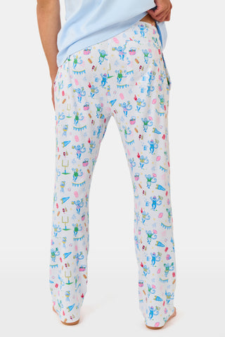 The Mens Game Day Troy Pajamas set by Roller Rabbit features a light blue short-sleeve t-shirt paired with white pajama pants decorated with colorful, playful cartoon animal and toy prints. The set is displayed on a plain white background.
