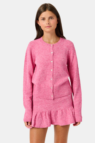 A girl wearing a pink AFFINA Kids Coco Sweater and matching skirt with a ruffled hem, paired with gold ballet flats.