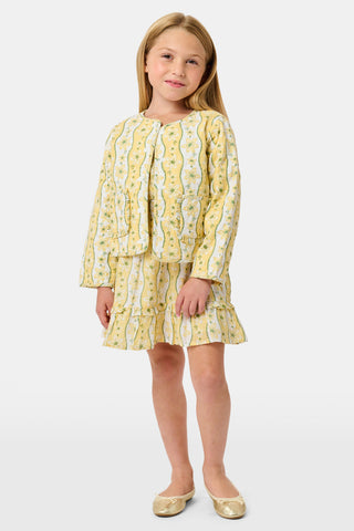 A young girl wearing a Roller Rabbit Kids Lillian Floral Stripe Finn Jacket paired with a matching ruffled skirt and gold ballet flats, standing and smiling against a plain white background—perfect for back-to-school style.