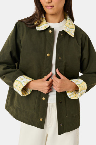 A young girl wearing a Roller Rabbit Kids Lillian Floral Stripe Finn Jacket paired with a matching ruffled skirt and gold ballet flats, standing and smiling against a plain white background—perfect for back-to-school style.