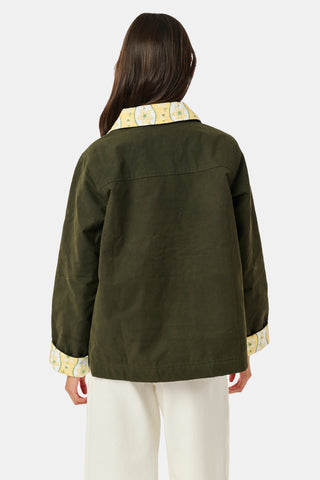 A young girl wearing a Roller Rabbit Kids Lillian Floral Stripe Finn Jacket paired with a matching ruffled skirt and gold ballet flats, standing and smiling against a plain white background—perfect for back-to-school style.