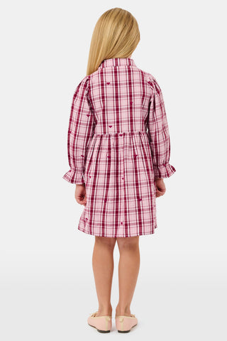 A girl wears a pink and white plaid hearts SAPPHIRE Kids Plaid Hearts Isabelle Dress with long sleeves and light-colored ballet flats.