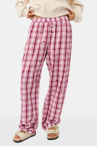 A woman wearing a SAPPHIRE Plaid Hearts Perlita Night Shirt in a pink and maroon plaid pattern with small hearts.
