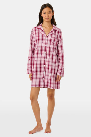 A woman wearing a SAPPHIRE Plaid Hearts Perlita Night Shirt in a pink and maroon plaid pattern with small hearts.