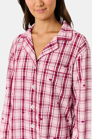 A woman wearing a SAPPHIRE Plaid Hearts Perlita Night Shirt in a pink and maroon plaid pattern with small hearts.