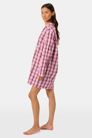 A woman wearing a SAPPHIRE Plaid Hearts Perlita Night Shirt in a pink and maroon plaid pattern with small hearts.